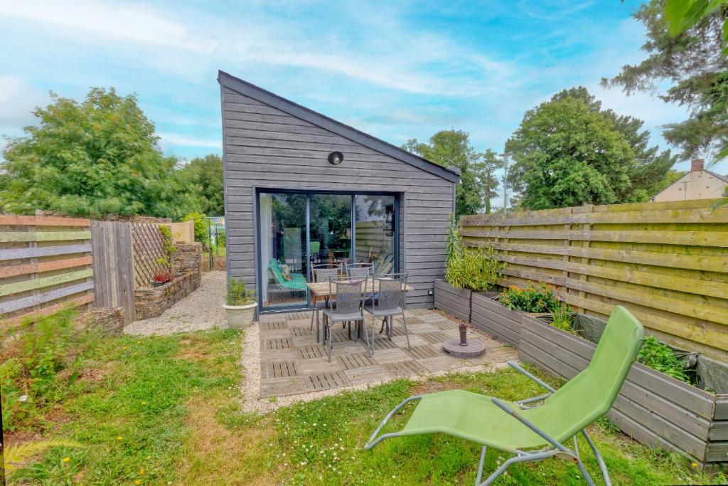 un petit hangar avec une table et des chaises dans une cour dans l'établissement Le Petit Nid, à Sainte-Reine-de-Bretagne
