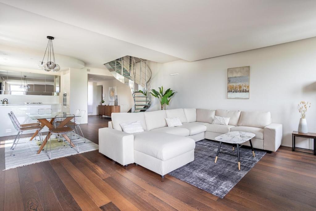 a living room with a white couch and a table at BePlace Apartments Arona in Arona