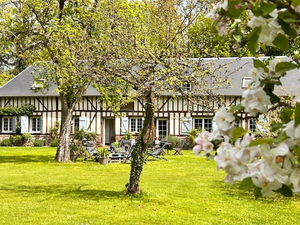 a white house with trees in front of it at La Chambre d'hôte de Manou en Normandie in La Noë-Poulain