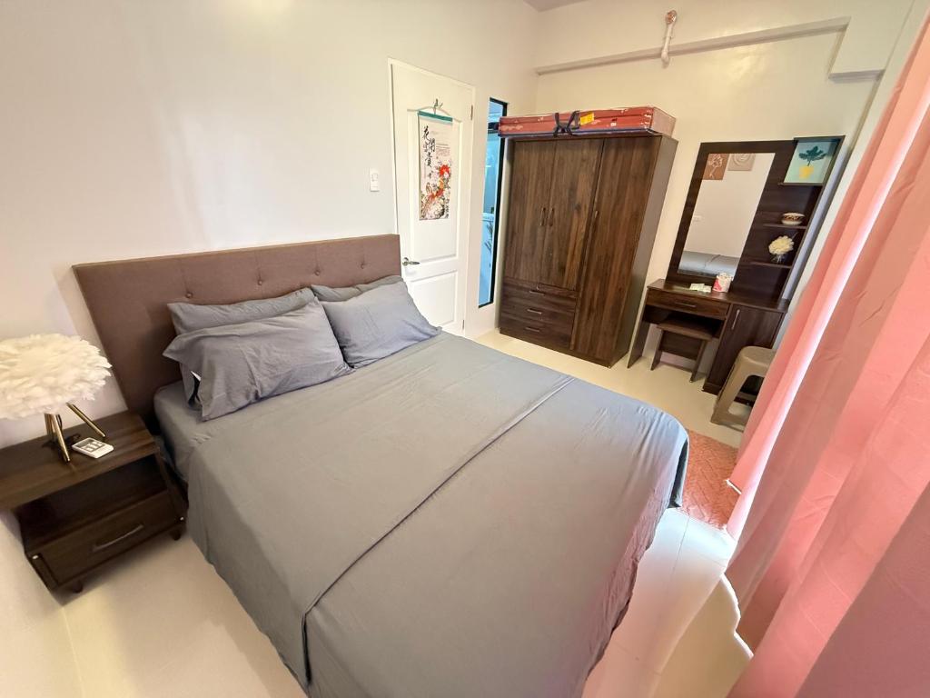 een kleine slaapkamer met een bed en een bureau bij Lecels Haven Place in Dauis