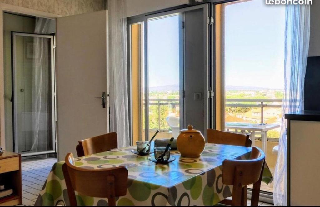 une salle à manger avec une table et des chaises et une grande fenêtre dans l'établissement Beau 2 pièces FRONT DE MER, proche commerces, à Canet