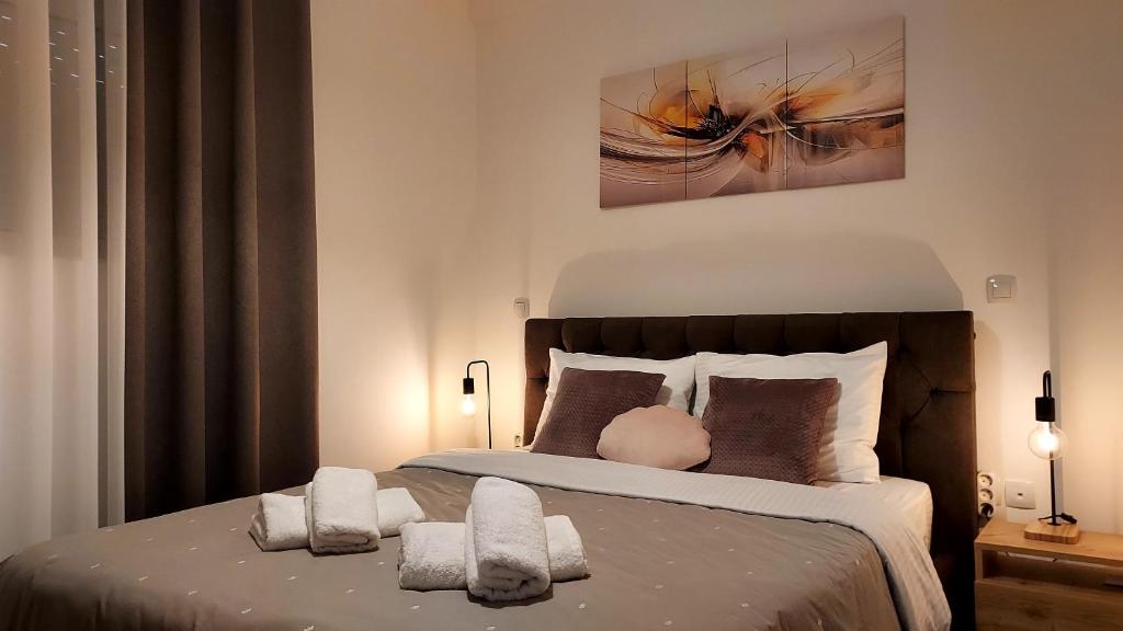 Un dormitorio con una cama grande con dos almohadas. en Melinta Stay - Near Airport, Rafina Port & Sea, en Artemida