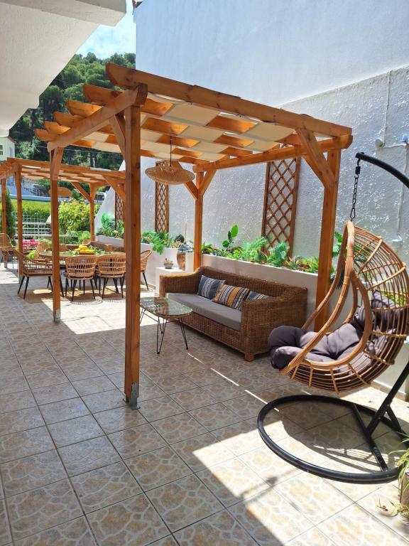 a patio with a hammock under a wooden pergola at Vithos in Agnontas