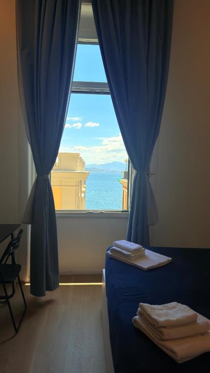 a bedroom with a window with a view of the ocean at Izz Home in Naples