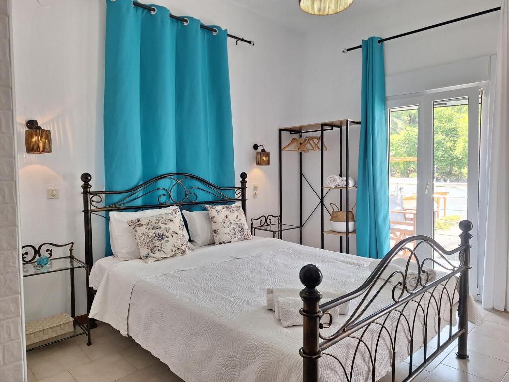 a bedroom with a bed with blue curtains at Vithos in Agnontas