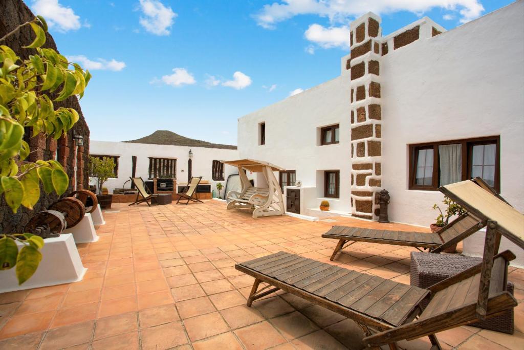 a patio with two benches on top of a building at Casa Rural La Molina in Máguez