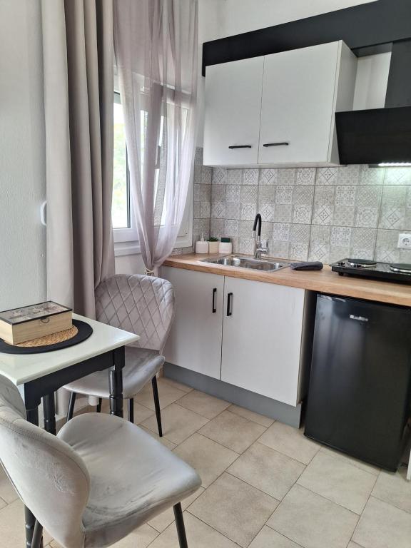 a kitchen with white cabinets and a table and a sink at Vithos in Agnontas