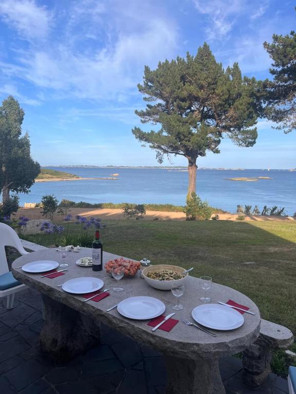 - une table avec des assiettes de nourriture et une bouteille de vin dans l'établissement La Bretonne vue mer, à Lanmodez