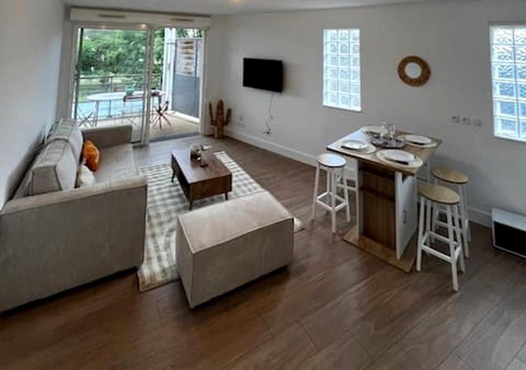 un salon avec un canapé et une table dans l'établissement Vaste studio au centre de La Teste de Buch, à La Teste-de-Buch