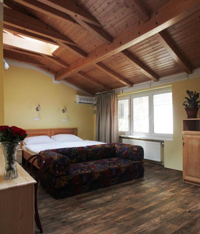 a living room with a couch and a bed at Hotel Orix in Jáchymov
