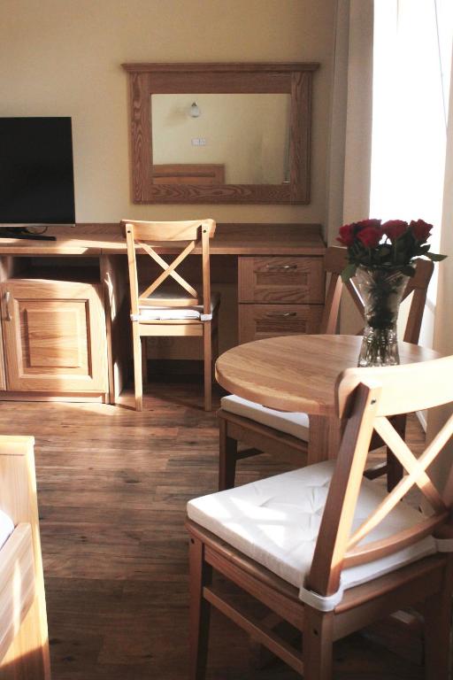 a dining room with a table and a mirror at Hotel Orix in Jáchymov