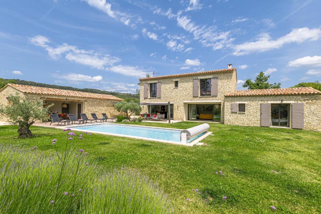 une maison avec une piscine dans une cour dans l'établissement La Vie Joly, à Gordes