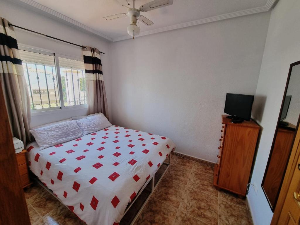 ein kleines Schlafzimmer mit einem Bett und einem Fernseher in der Unterkunft Amanecer Costero in Orihuela