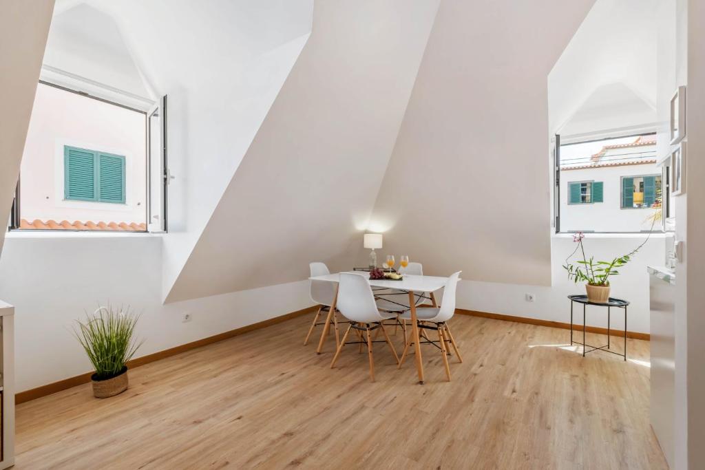 a dining room with a table and two windows at Nati by KAAMAH in Ribeira Brava