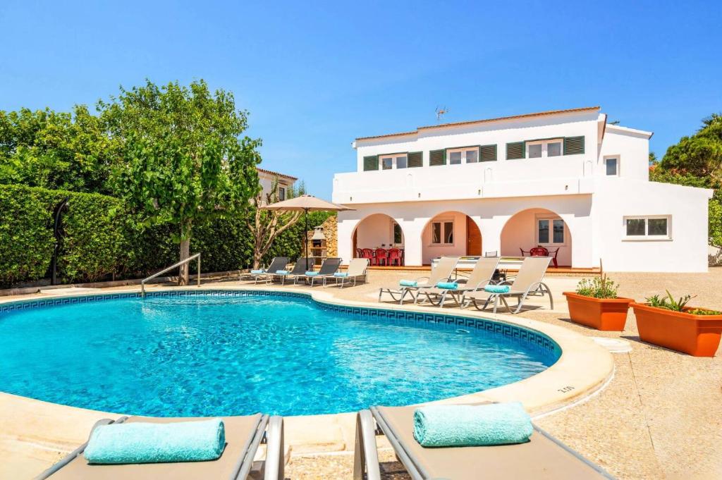 a villa with a swimming pool and a house at Villa Tres Arcos by Villa Plus in Cala en Blanes
