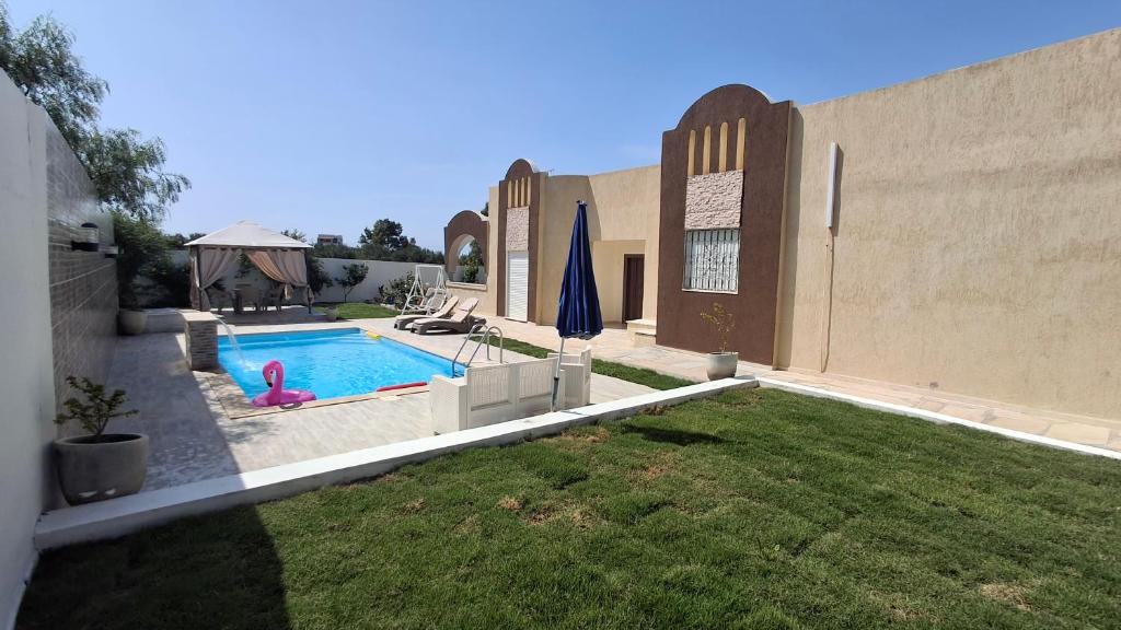 a house with a swimming pool in a yard at Villa lucky in Hammamet