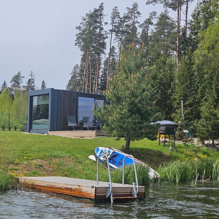 a small house on a dock in the water at REZi Cabin in Krogzemnieki