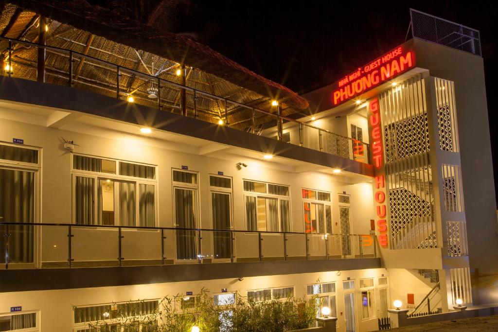a building with a neon sign in front of it at Phuong Nam Guest House in Mui Ne