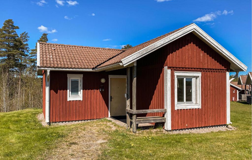 a red shed with a door in a yard at Schönes Zuhause In Hokjönköpingskillingaryd in Svenstorp