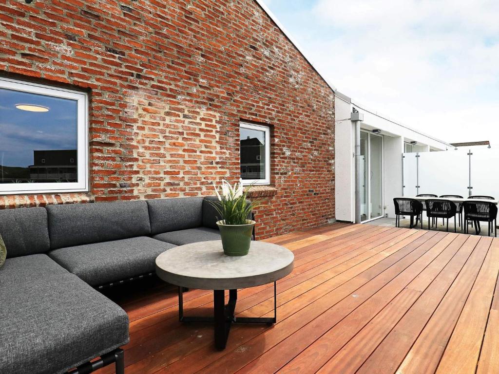 een woonkamer met een bank en een tafel bij 6 person holiday home in Ringkøbing in Ringkøbing