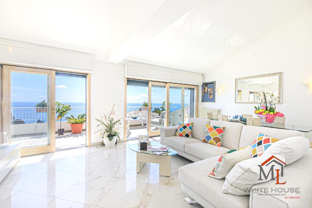 a living room with white furniture and a view of the ocean at Orchidea House by ML WHITE HOUSE in Genova