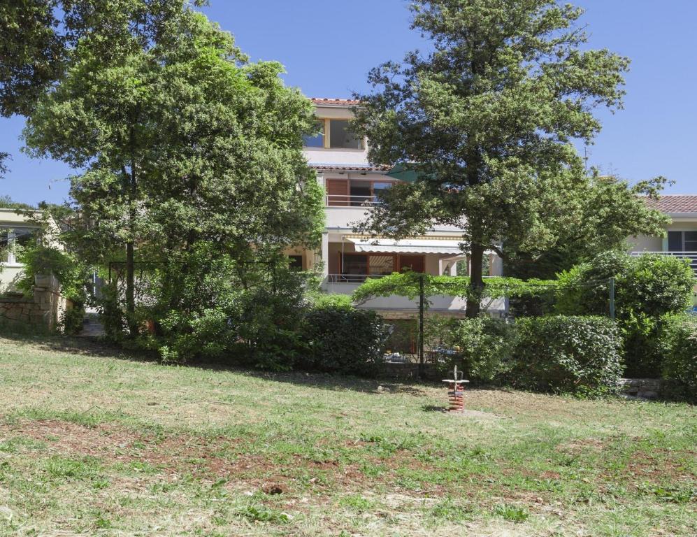 un edificio con árboles frente a un patio en Apartments Kump, en Rovinj