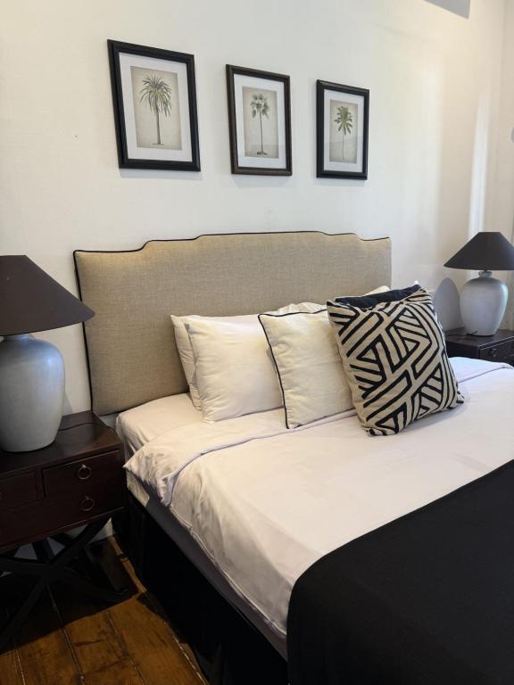 a bedroom with a bed with three pictures on the wall at Saige House - Room in Shared Villa in Canggu