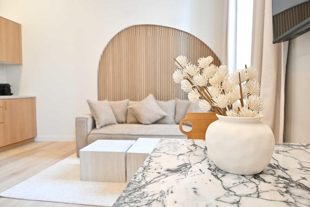 un salon avec un vase et des fleurs sur une table dans l'établissement Superb Apartment Center of Paris Le Marais, à Paris