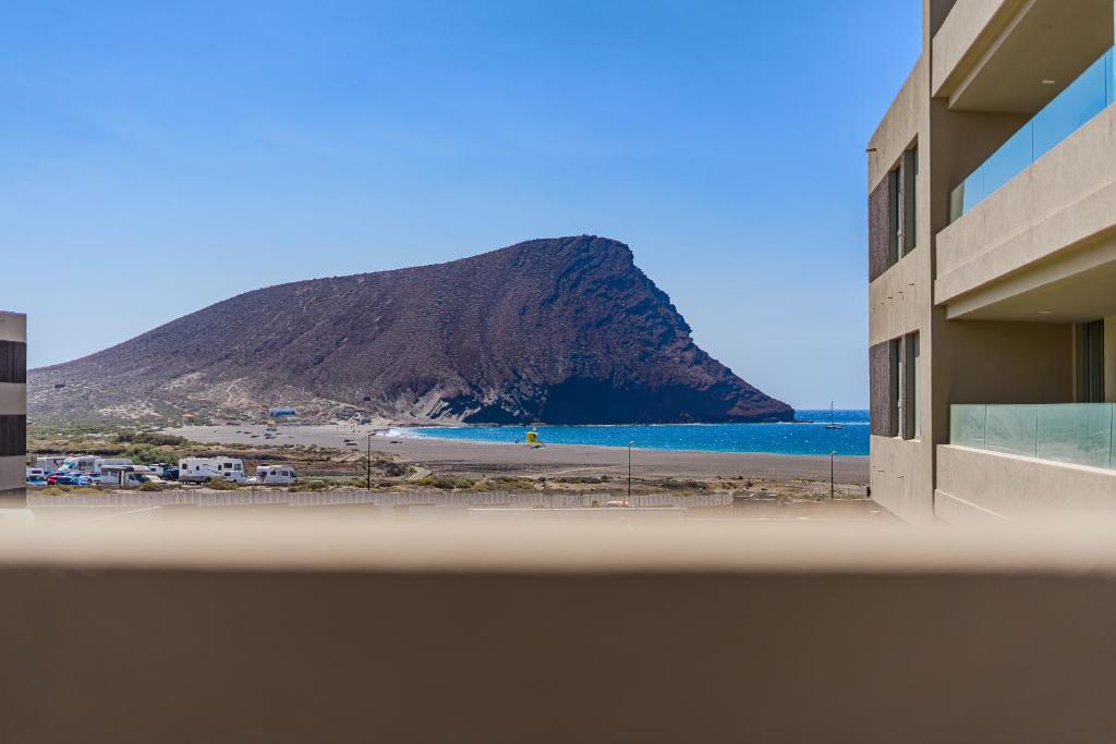 a view of a beach with a mountain in the background at Oceanfront Oasis - Stunning beach view apartment in El Médano