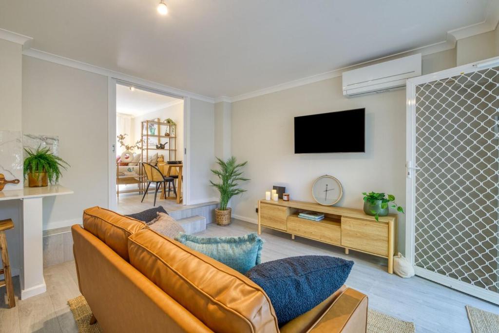 パースにあるCottesloe Studio Getawayのソファとテレビのあるリビングルーム