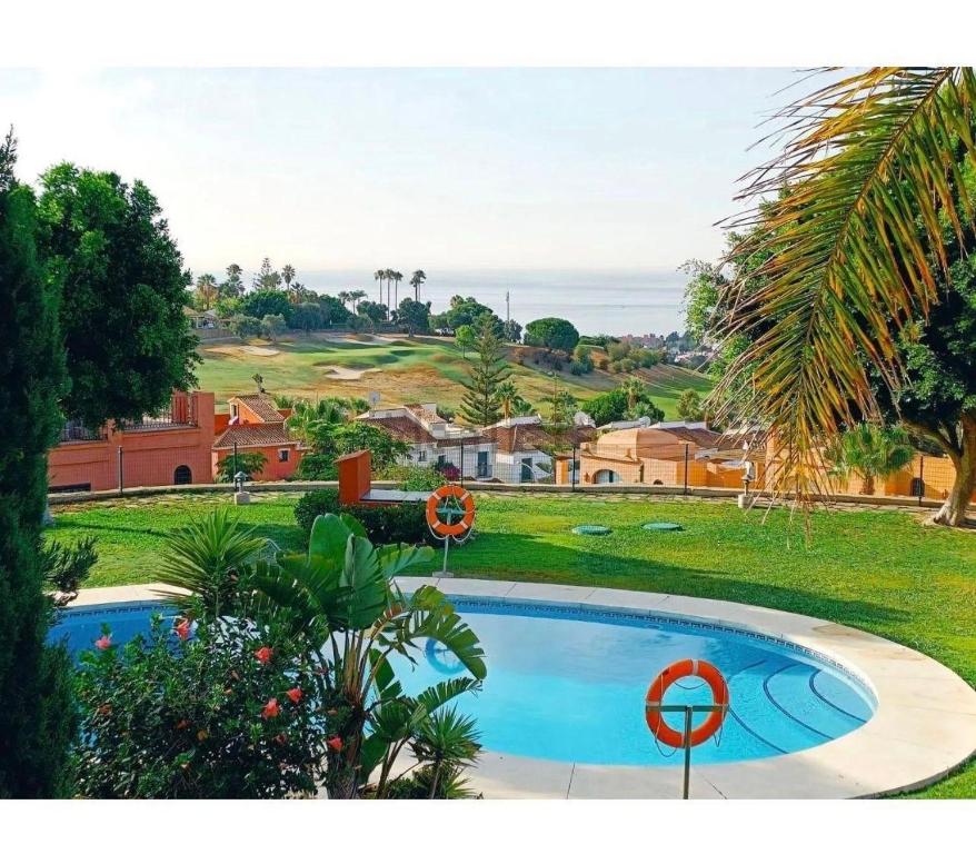 a view of a swimming pool and a golf course at Las Colinas Beach in Manilva