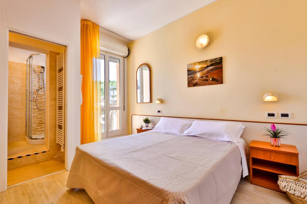 a bedroom with a bed and a window at Hotel Paola Garden in Rimini