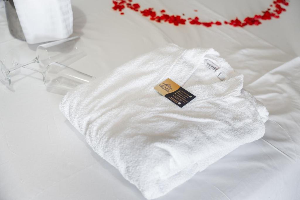 un maglione bianco con un'etichetta su un letto di Hotel Lula Ksamil a Ksamil