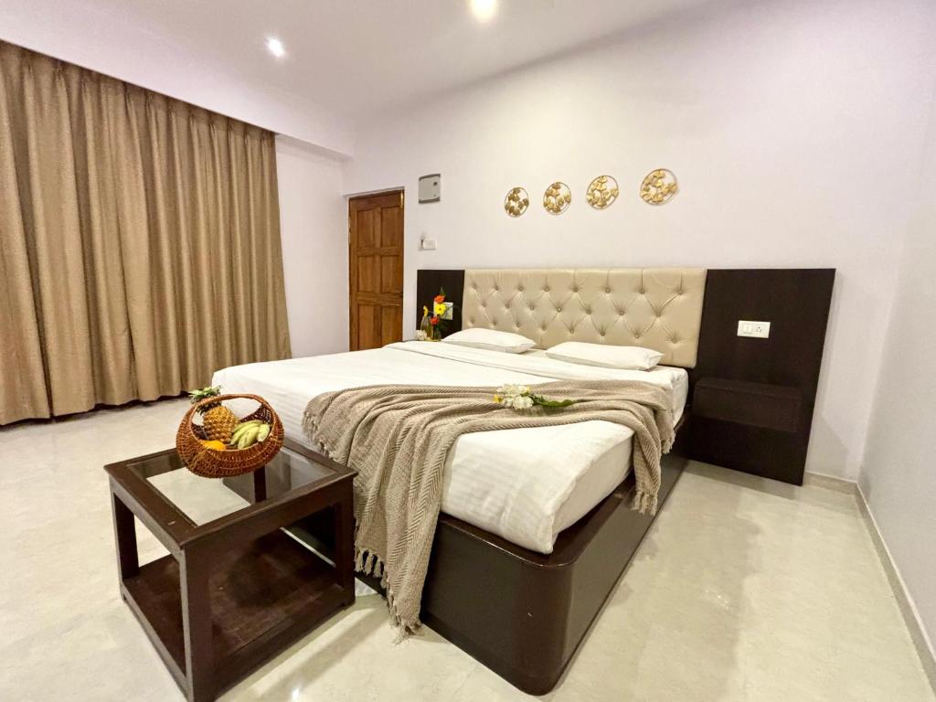 Un dormitorio con una cama grande y una mesa. en Casa de Laura, en Calangute