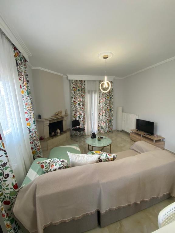 ein Schlafzimmer mit einem großen Bett und ein Wohnzimmer in der Unterkunft Gianna's house in Nikiti