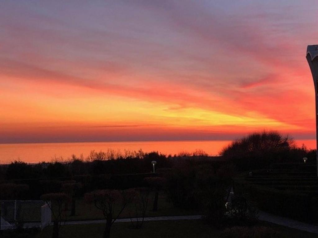 un coucher de soleil sur l'eau avec le ciel dans l'établissement Première ligne au Couchant Appartement t3 pour 6 personnes N112, à La Grande Motte