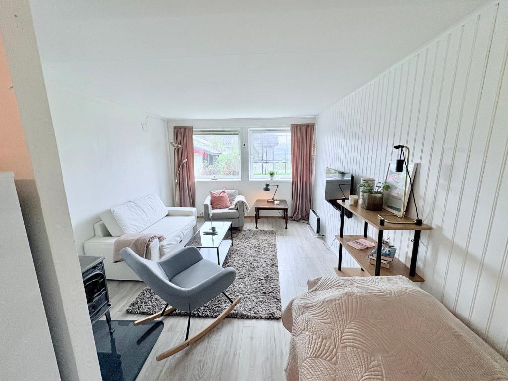 a living room with a couch and a chair at Cozy apartment close to nature in Tromsø