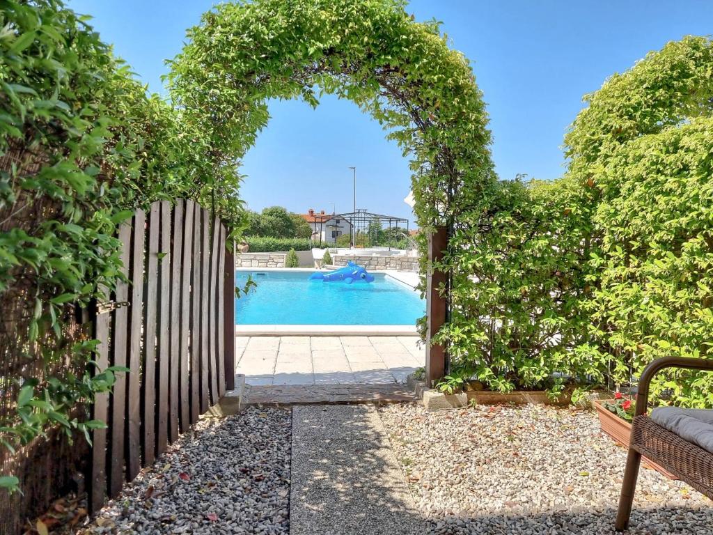 an archway leading to a pool in a yard at Olimpia 3 in Novigrad Istria