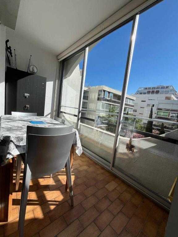 une salle à manger avec une table et une grande fenêtre dans l'établissement Cœur de Ville Appartement studio pour 5 personnes N125, à La Grande Motte