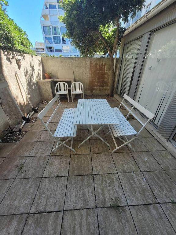 - une table de pique-nique et 2 chaises sur la terrasse dans l'établissement Appartement T3 centre ville de la Grande Motte N24, à La Grande Motte