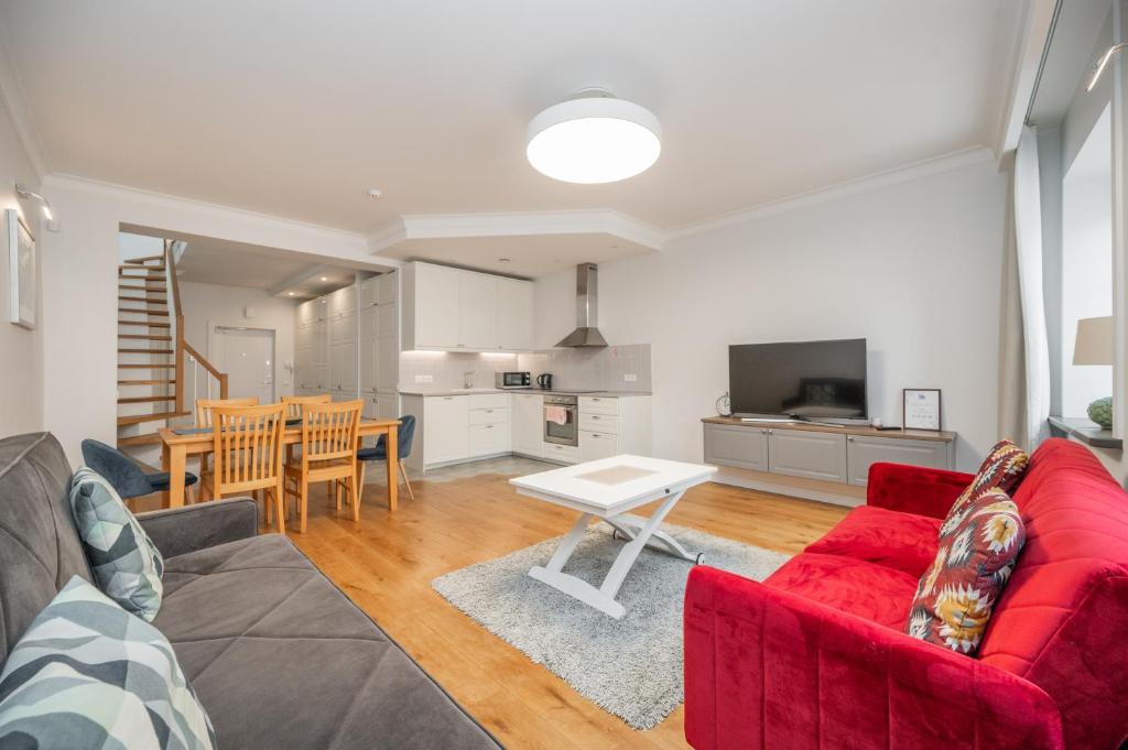 un salon avec un canapé rouge et une table dans l'établissement Twin apartments 3 Bedr by Reside Baltic, à Vilnius