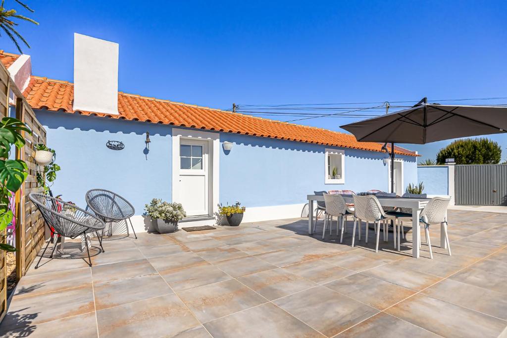 a patio with a table and chairs and an umbrella at Craveira Country House - Monte da Craveira in Sonega