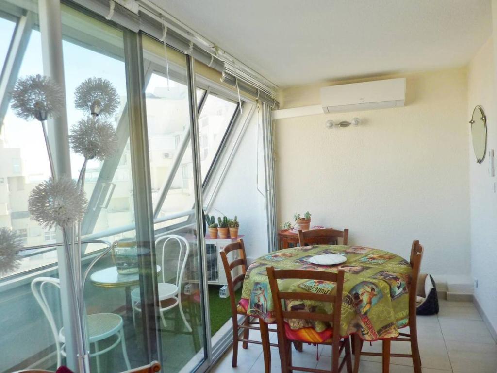 une salle à manger avec une table et des chaises et une fenêtre dans l'établissement Cœur de ville Appartement t2 pour 4 personnes N22, à La Grande Motte
