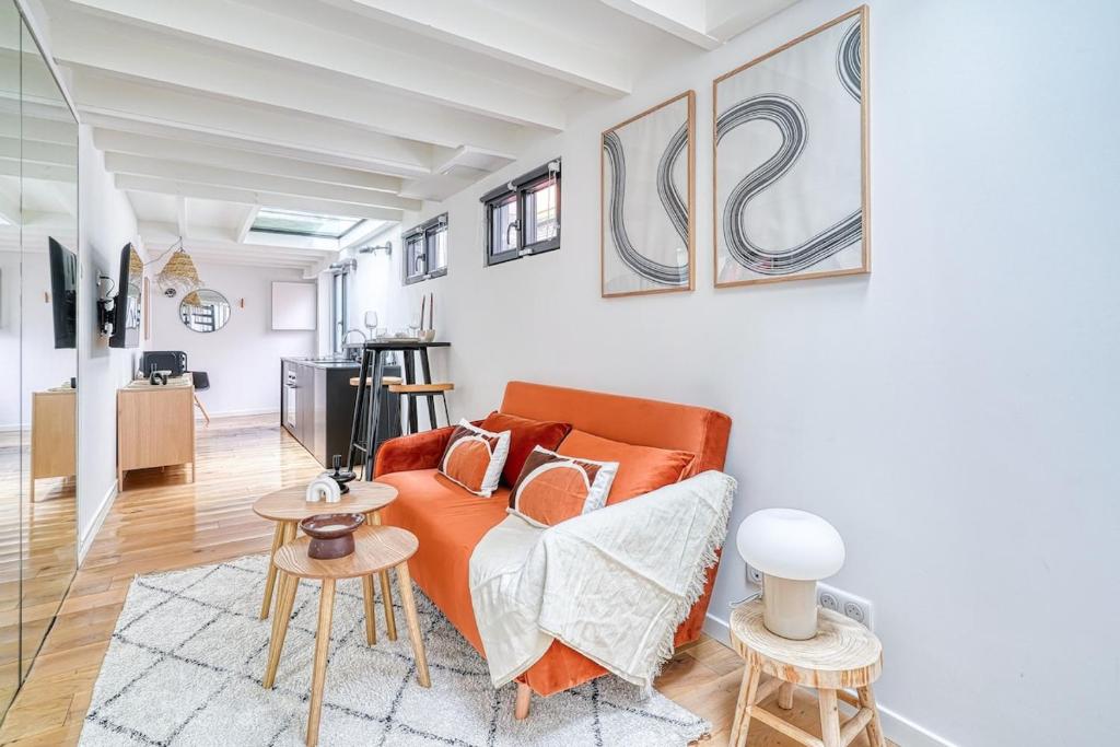 un salon avec un canapé orange et une table dans l'établissement Superbe Loft lumineux Paris Alesia- II, à Paris