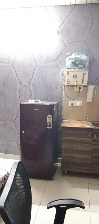 a room with a black refrigerator and a chair at NK Hotels in Jāmb