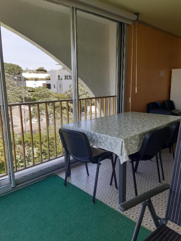 Cette chambre dispose d'un balcon avec une table et des chaises. dans l'établissement Quartier Point Zéro appartement studio pour 5 personnes N3, à La Grande Motte