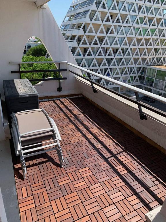 une chaise sur le balcon d'un bâtiment dans l'établissement Coeur de ville Appartement t3 pour 6 personnes N7, à La Grande Motte