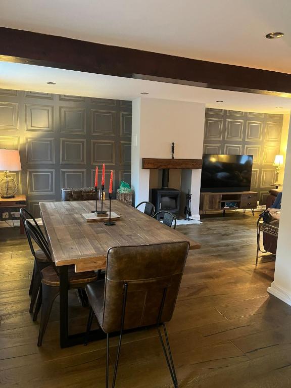 a dining room with a table and a living room at 3 Bedroom Dog Friendly Cottage with Off Lead Field in Airton