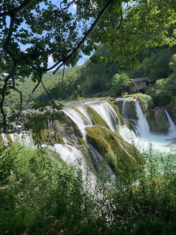 a waterfall in the middle of a river at Dream House Šeha in Bihać