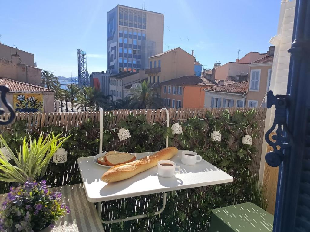 une table avec une assiette de nourriture sur un balcon dans l'établissement Vu port 2 personnes avec vélos, à La Seyne-sur-Mer
